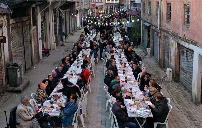 Mahalleli fazladan yaptığı yemekleri sokakta kurulan iftar sofrasında paylaşıyor